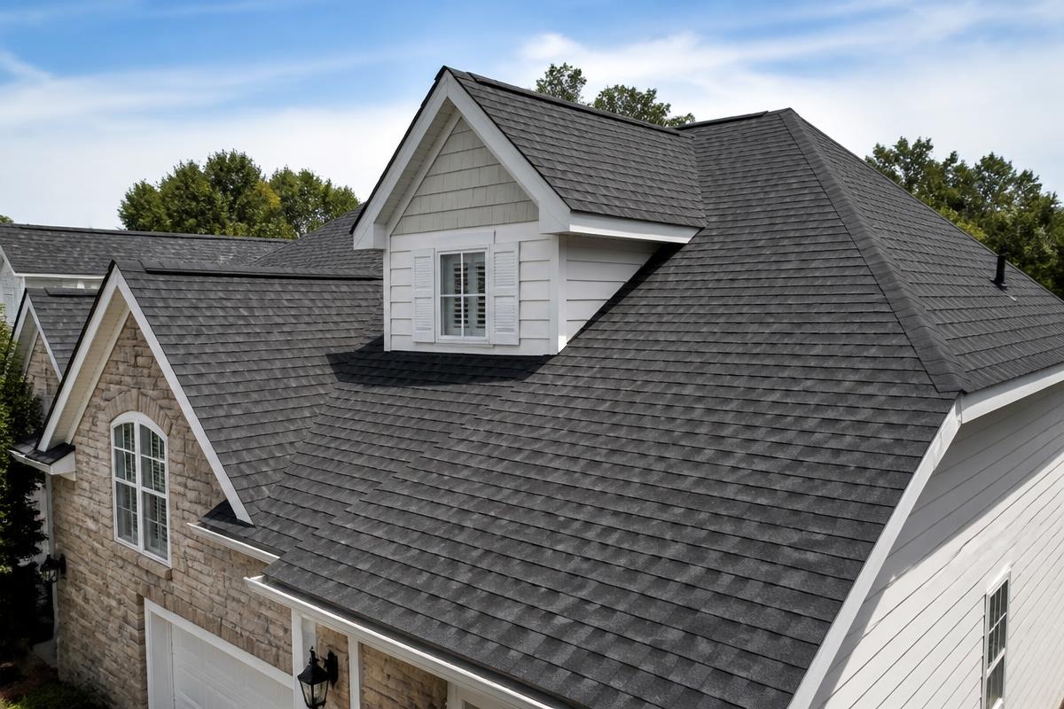 Newly installed dark gray asphalt shingle roof on a suburban home